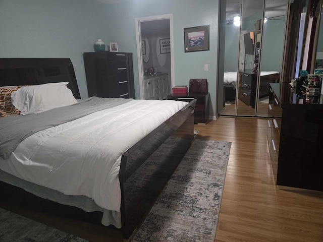 bedroom with wood-type flooring and a closet