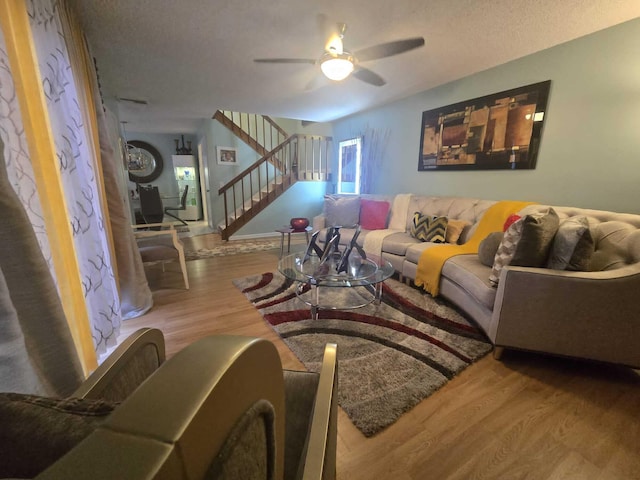 living room with ceiling fan, hardwood / wood-style floors, and a textured ceiling