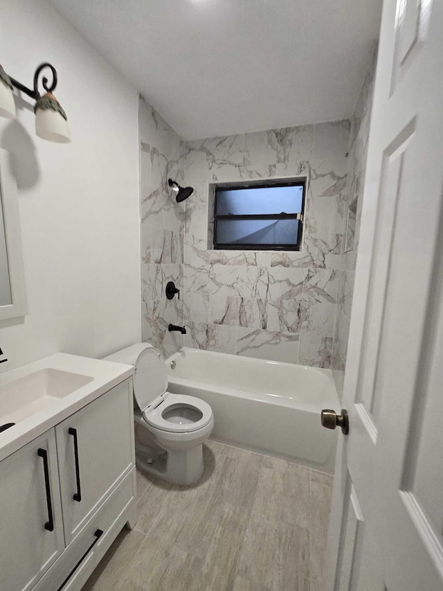 full bathroom featuring hardwood / wood-style flooring, tiled shower / bath, vanity, and toilet