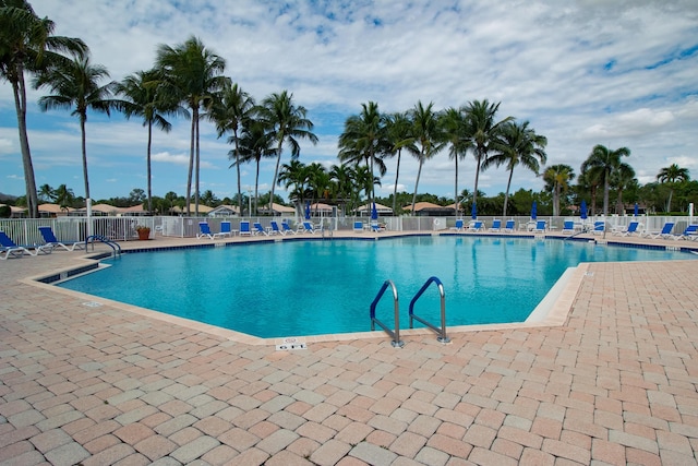 pool featuring fence and a patio