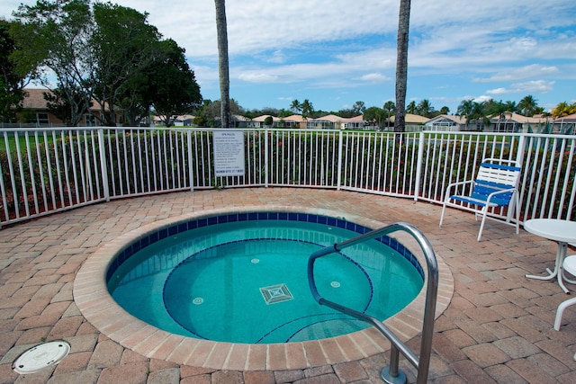 view of pool with a patio area, a hot tub, and fence