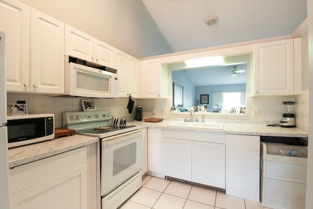 kitchen featuring white appliances, tasteful backsplash, white cabinets, and a sink