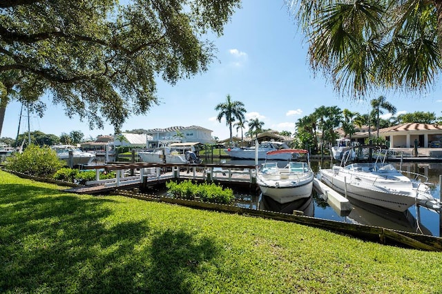 view of dock with a water view and a yard