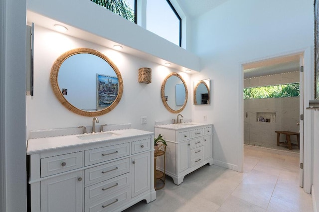 bathroom with vanity, a towering ceiling, and a shower