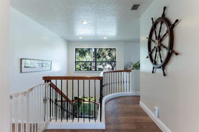 hallway featuring hardwood / wood-style flooring and a textured ceiling