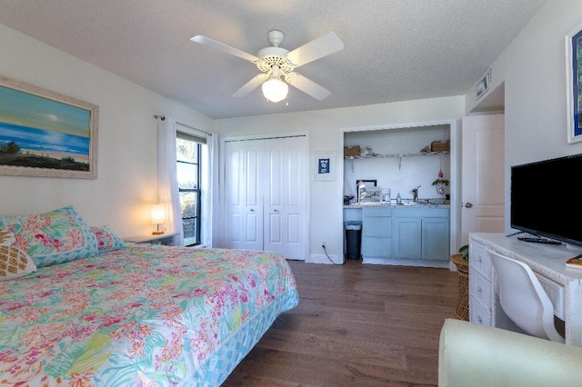 bedroom with ceiling fan, a textured ceiling, and dark hardwood / wood-style flooring