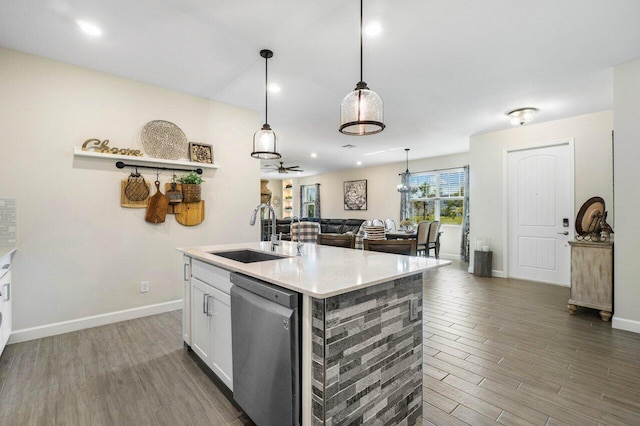 kitchen with sink, dishwasher, white cabinetry, hanging light fixtures, and an island with sink