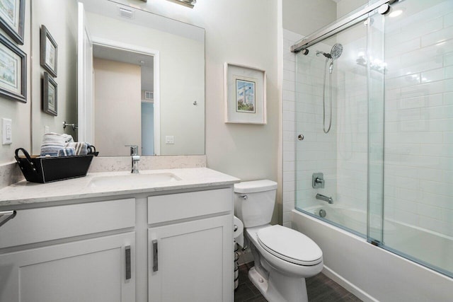 full bathroom featuring hardwood / wood-style flooring, enclosed tub / shower combo, vanity, and toilet