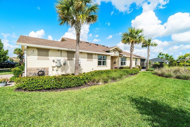 rear view of property featuring a lawn