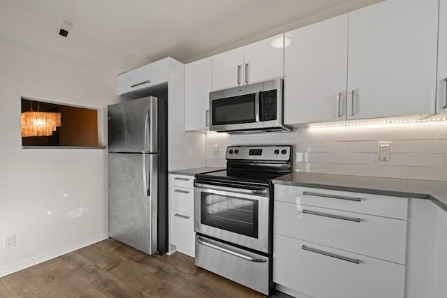 4640 Lucerne Lakes Blvd Unit 306, Lake Worth, FL 33467 - kitchen with appliances with stainless steel finishes, dark wood finished floors, decorative backsplash, and white cabinets