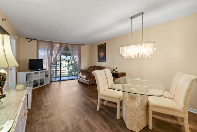 dining space featuring a textured ceiling, dark hardwood / wood-style floors, and a notable chandelier