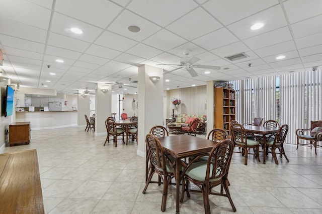 dining room featuring ceiling fan, light tile patterned floors, and a paneled ceiling