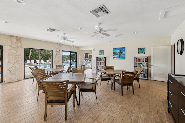 dining room featuring ceiling fan, light hardwood / wood-style flooring, and a textured ceiling