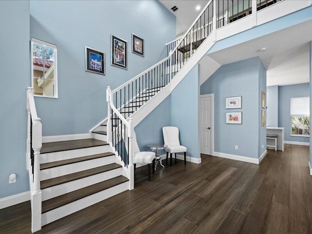 staircase featuring hardwood / wood-style floors and a high ceiling