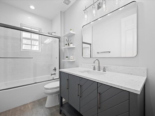 full bathroom featuring vanity, enclosed tub / shower combo, and toilet