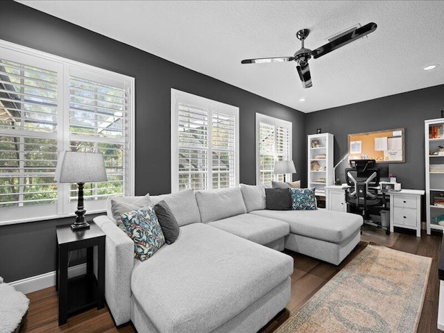 living room featuring dark hardwood / wood-style flooring, ceiling fan, plenty of natural light, and a textured ceiling