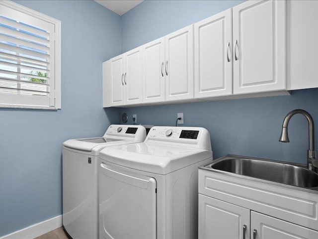 laundry area featuring sink, cabinets, and independent washer and dryer