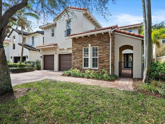 mediterranean / spanish-style home with a garage and a front yard