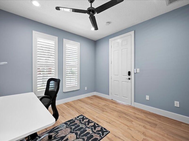 office space featuring a textured ceiling, light hardwood / wood-style floors, and ceiling fan