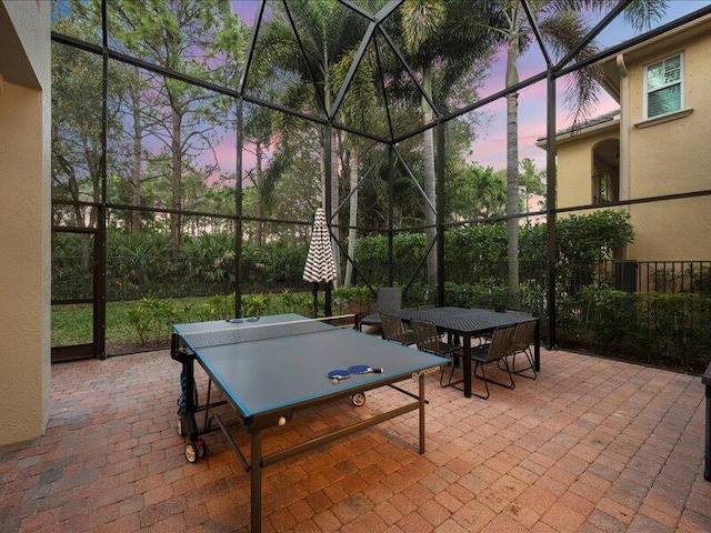 patio terrace at dusk featuring a lanai