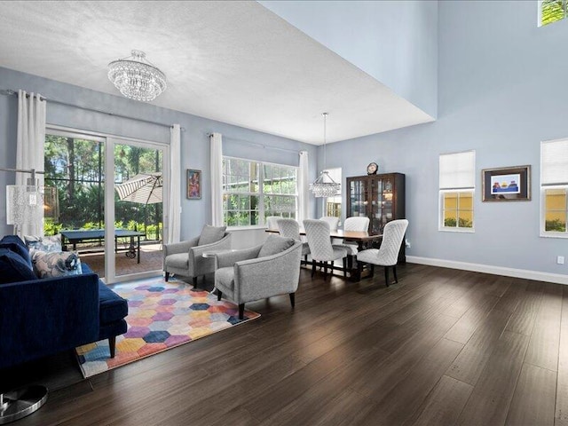 living room with dark wood-type flooring and a notable chandelier