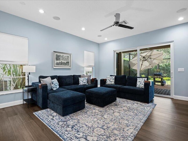 living room with dark wood-type flooring and ceiling fan