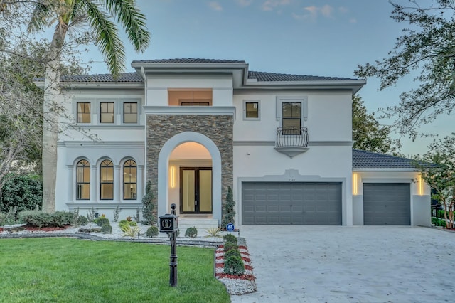 mediterranean / spanish-style home with a front yard and a garage