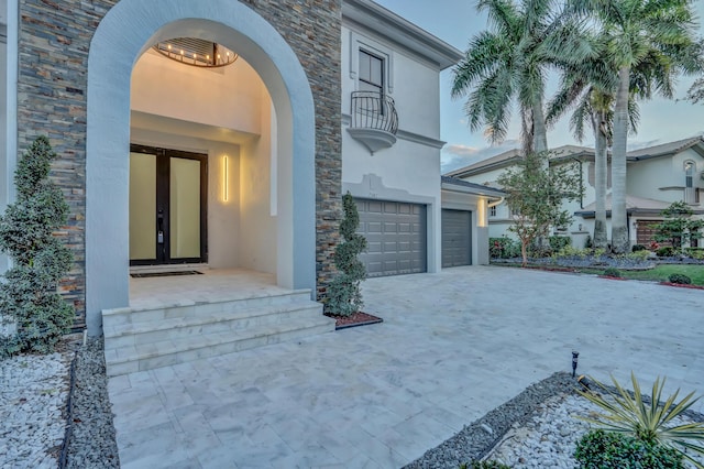 property entrance featuring a garage and a balcony