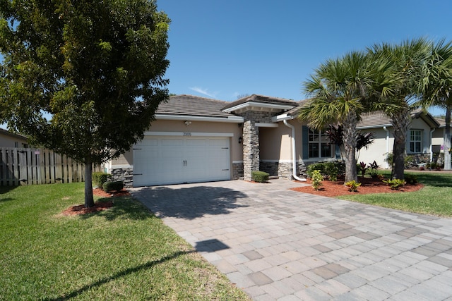 view of front of home featuring fence, an attached garage, stucco siding, stone siding, and decorative driveway