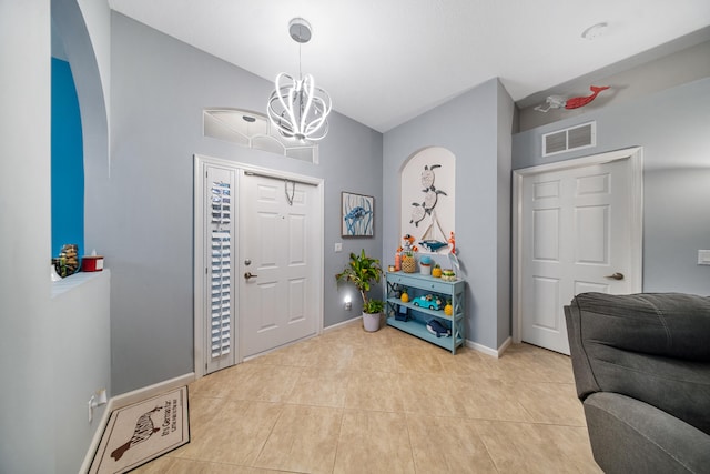 tiled entryway featuring a chandelier