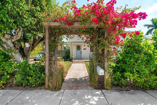 entrance to property featuring fence and stucco siding