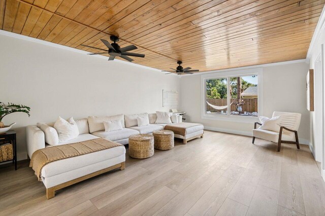 living area featuring arched walkways, ornamental molding, wood ceiling, wood finished floors, and baseboards