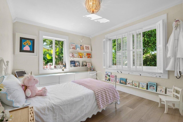 bedroom featuring ornamental molding, multiple windows, and wood finished floors