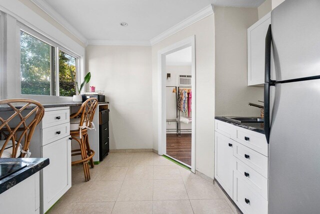 doorway to outside featuring ornamental molding, built in desk, light tile patterned flooring, and recessed lighting