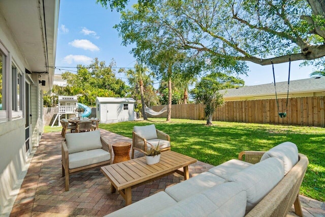 view of patio / terrace featuring a storage unit, an outdoor structure, a fenced backyard, and an outdoor living space