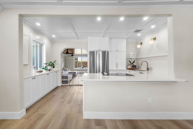 kitchen featuring black electric cooktop, a peninsula, white cabinetry, light wood-style floors, and freestanding refrigerator