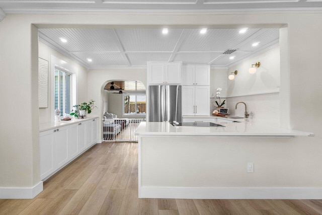 1630 N Ocean Breeze, Lake Worth Beach, FL 33460 - kitchen featuring freestanding refrigerator, crown molding, light wood-style floors, white cabinets, and a peninsula
