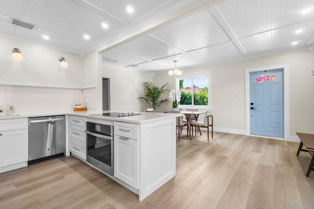 kitchen with appliances with stainless steel finishes, visible vents, light wood-style flooring, and a peninsula