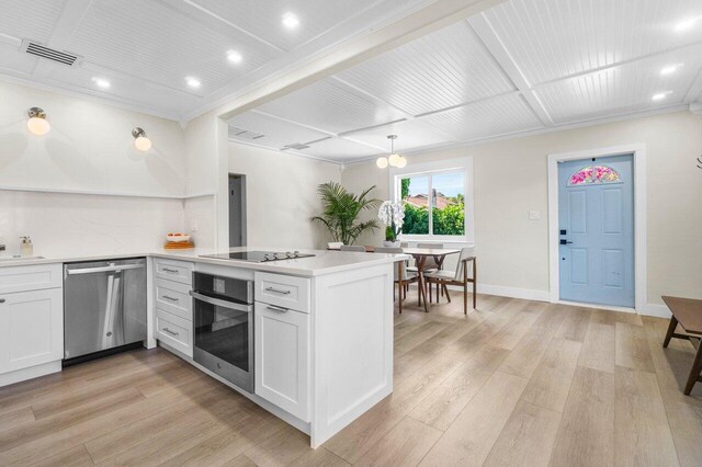 kitchen featuring arched walkways, light countertops, light wood-style flooring, and freestanding refrigerator