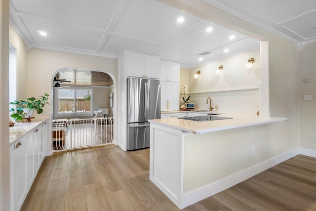 1630 N Ocean Breeze, Lake Worth Beach, FL 33460 - kitchen with freestanding refrigerator, arched walkways, ornamental molding, light wood finished floors, and light countertops