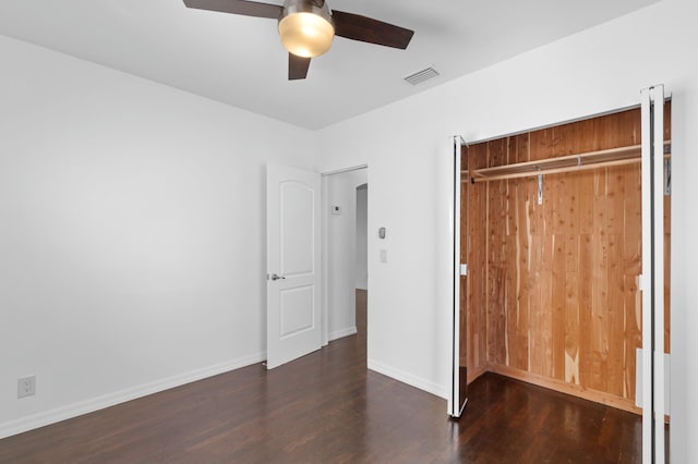 unfurnished bedroom with dark wood-type flooring, ceiling fan, and a closet