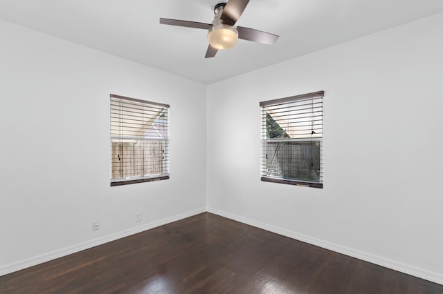 spare room featuring dark wood-type flooring and ceiling fan