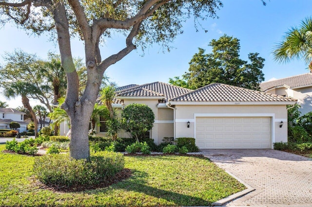 mediterranean / spanish home featuring a front lawn and a garage