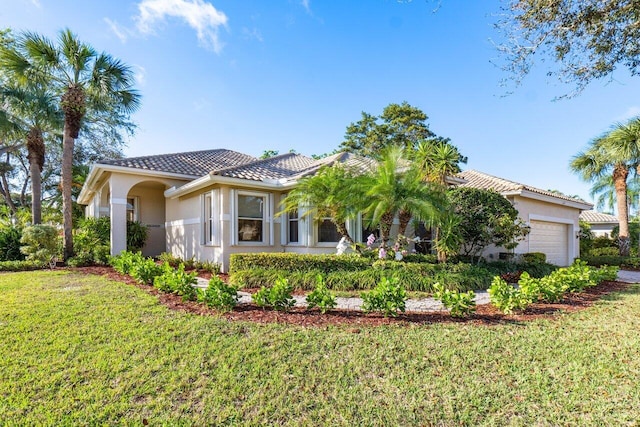 mediterranean / spanish-style home with a garage and a front lawn