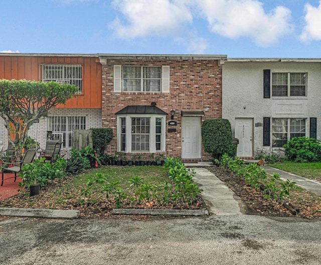 townhome / multi-family property featuring board and batten siding and brick siding