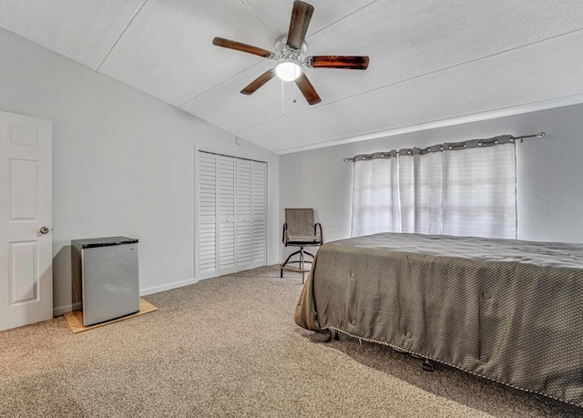 bedroom with ceiling fan, a textured ceiling, vaulted ceiling, freestanding refrigerator, and carpet