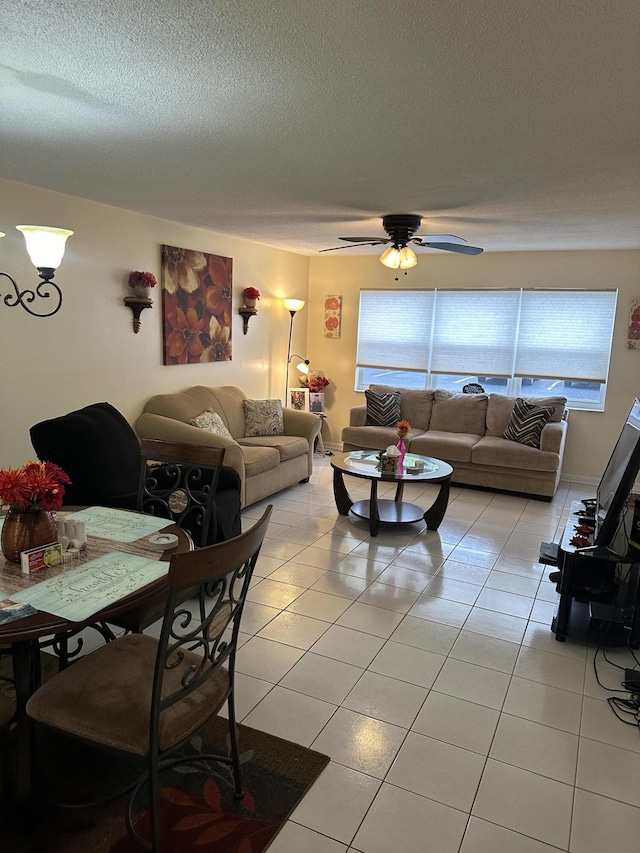 living room featuring light tile patterned flooring, ceiling fan, and a textured ceiling