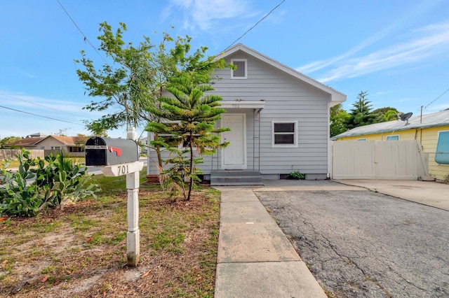 bungalow-style home with a gate and fence