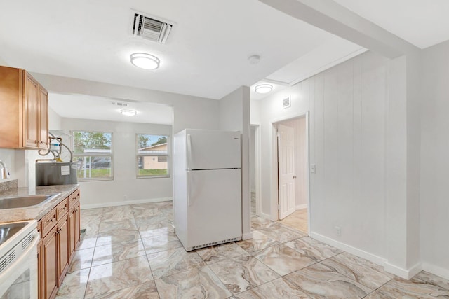 kitchen featuring white appliances, a sink, visible vents, marble finish floor, and light countertops