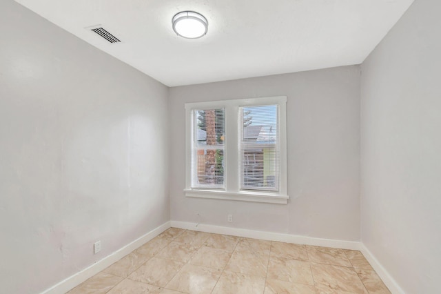 unfurnished room with baseboards and visible vents